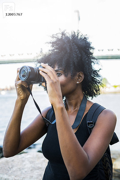 USA  New York City  Brooklyn  Frau beim Fotografieren am Wasser