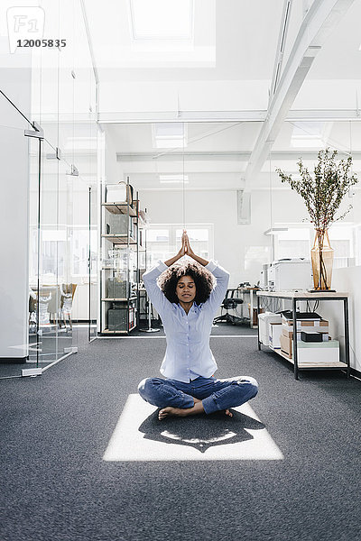 Junge Frau beim Yoga im Büro