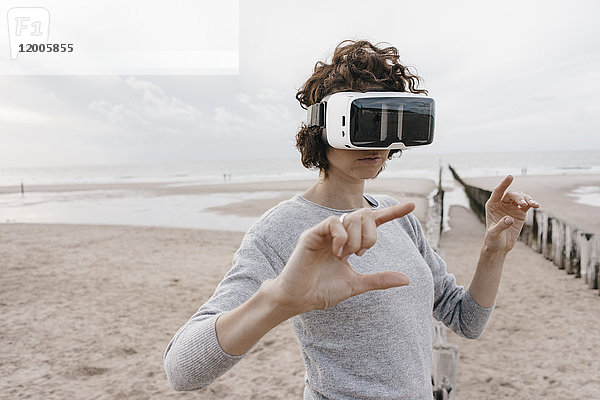 Frau am Strand mit VR-Brille