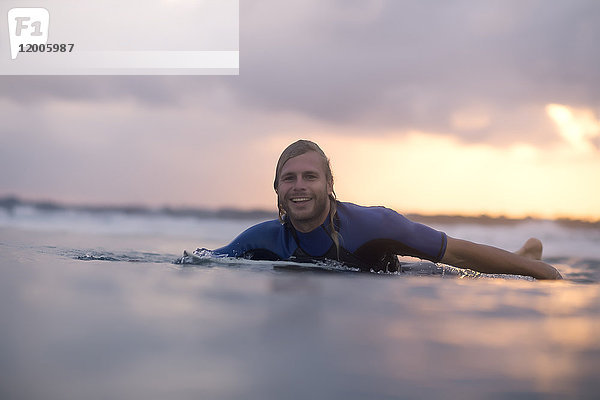 Indonesien  Bali  Surfer im Meer bei Sonnenaufgang
