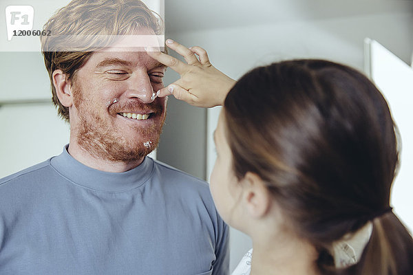 Tochter legt Gesichtscreme auf Vaters Gesicht