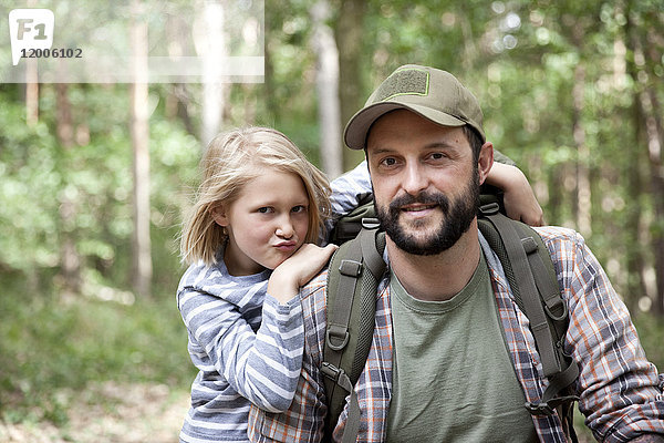 Porträt von lächelndem Vater und Tochter im Wald