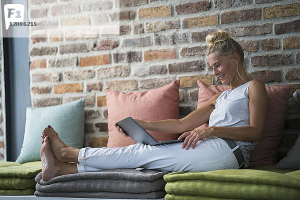 Reife Frau sitzend auf der Couch  usine laptop