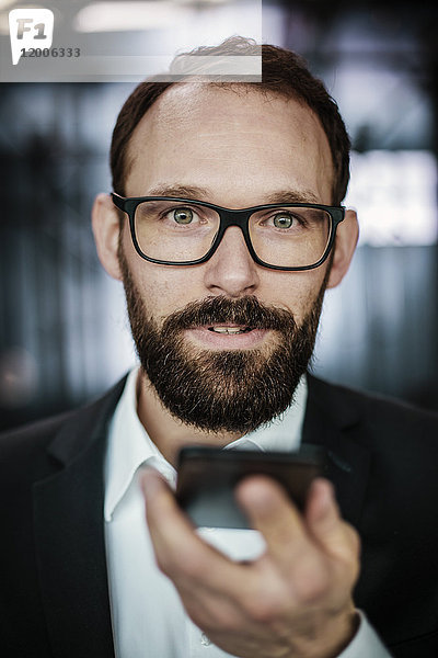 Porträt eines ambitionierten Geschäftsmannes mit Smartphone