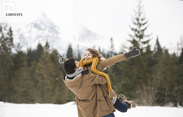 Glückliches junges Paar mit Spaß in der Winterlandschaft