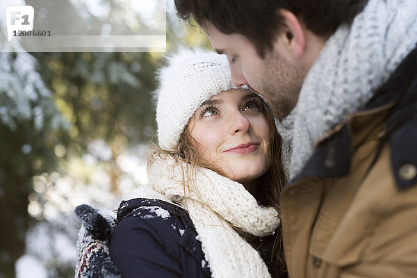 Portrait der glücklichen jungen Frau von Angesicht zu Angesicht mit ihrem Partner im Winter