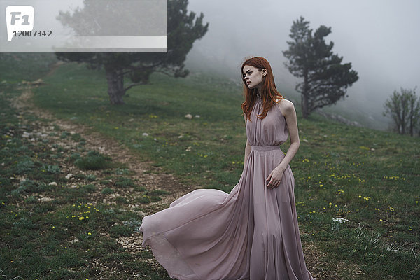 Kaukasische Frau trägt ein Kleid im Feld