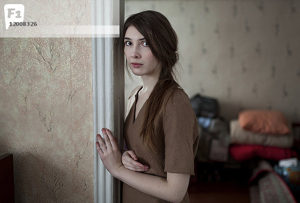 Ernste kaukasische Frau lehnt in der Tür