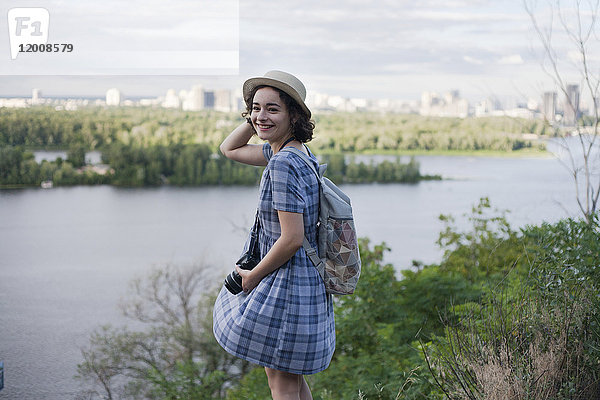 Porträt einer kaukasischen Frau mit Kamera am Fluss