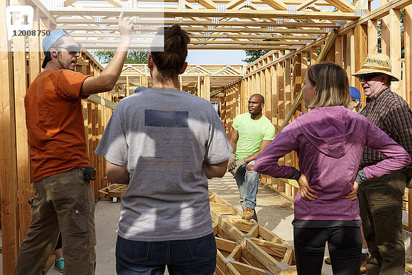 Freiwillige  die sich beim Bau eines Hauses unterhalten
