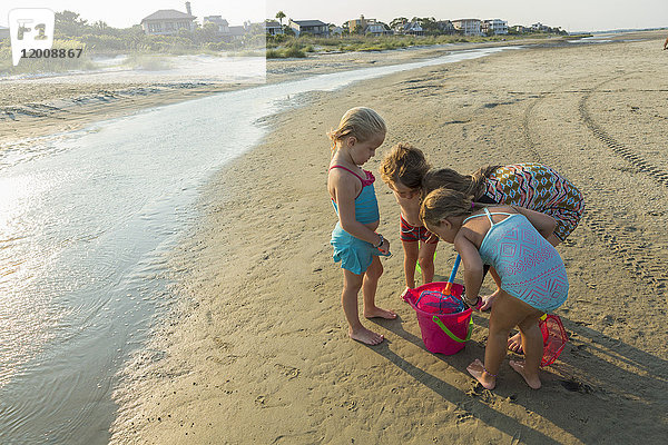 Kaukasischer Junge und Mädchen spielen mit Eimer am Strand