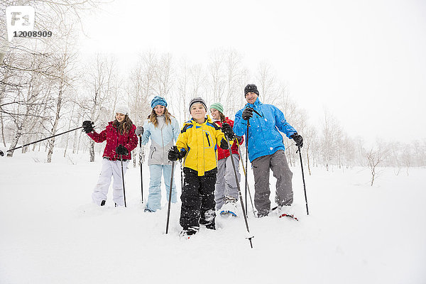 Porträt einer lächelnden kaukasischen Familie beim Schneeschuhwandern