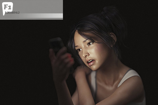 Mädchen schreibt eine SMS auf dem Handy und weint