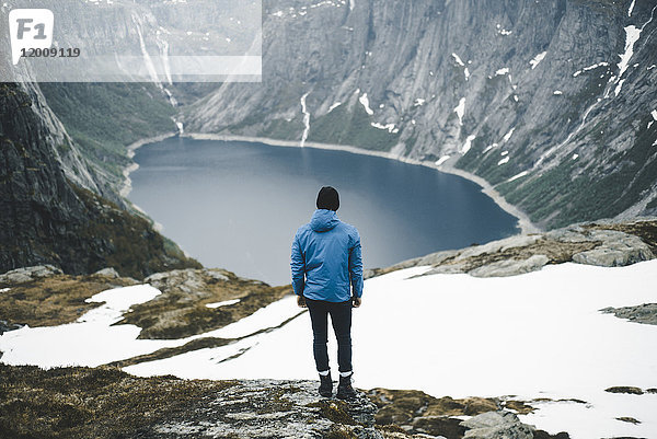 Kaukasischer Mann bewundert malerische Aussicht auf Bergsee