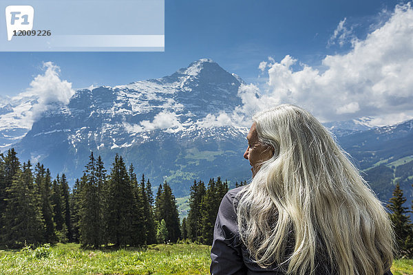 Kaukasische Frau bewundert malerische Aussicht auf einen Berg