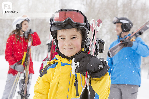 Porträt eines lächelnden kaukasischen Jungen mit Skiern