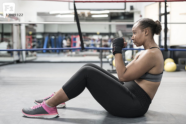 Schwarze Frau sitzt auf dem Boden im Boxring