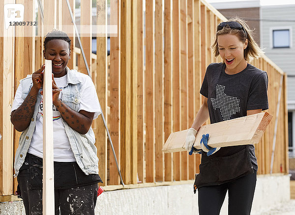 Freiwillige tragen Bauholz auf einer Baustelle