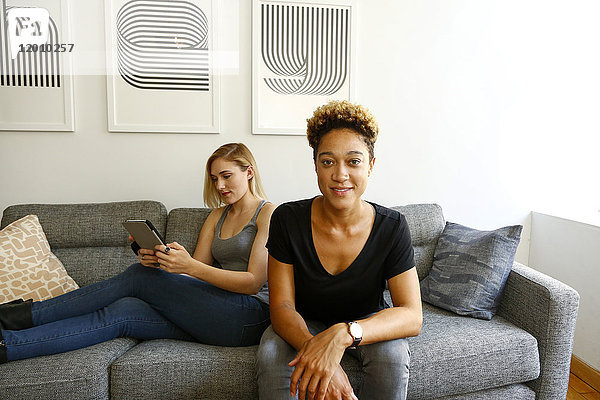Frauen auf dem Sofa sitzend mit digitalem Tablet