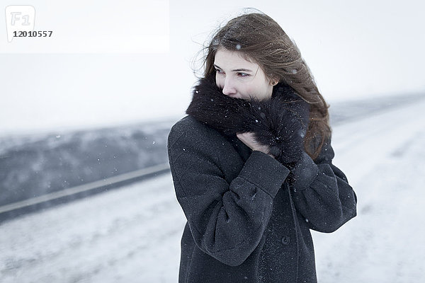 Kaukasische Frau mit Pelzkragen im Freien im Winter
