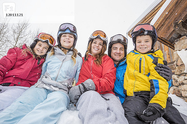 Porträt einer lächelnden kaukasischen Familie im Winterurlaub