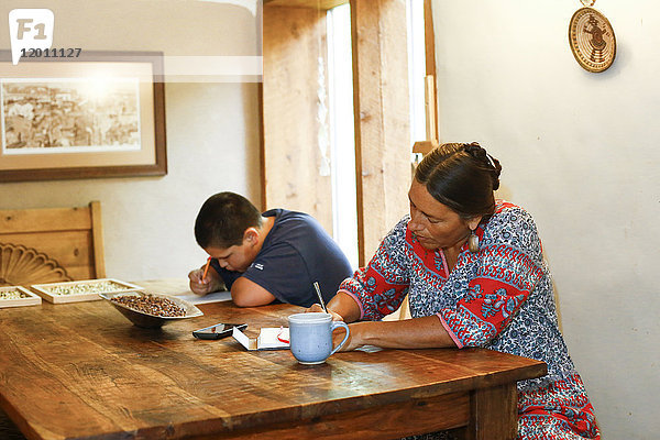 Mutter und Sohn schreiben am Tisch