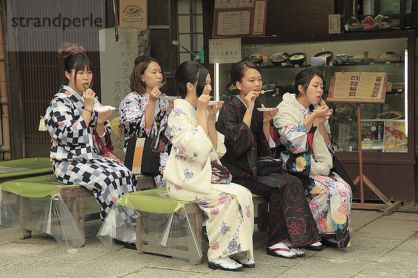 Japan  Kyoto  junge Frauen im Kimono essen Süßigkeiten