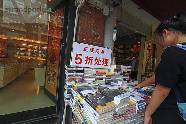 Asien  China  Shanghai. Chinesisches Mädchen schaut sich Bücher an