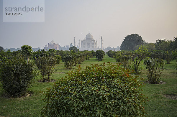 Außenansicht des Taj Mahal-Palastes und des Mausoleums  einer UNESCO-Weltkulturerbestätte  mit einer Dachlinie  die sich vor einem dämmrigen Himmel abzeichnet.