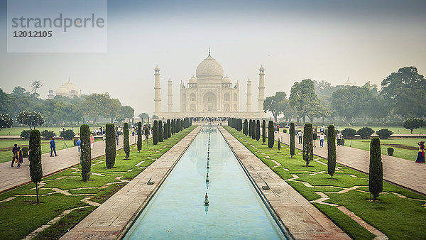 Außenansicht des Taj Mahal-Palastes und des Mausoleums  eines UNESCO-Weltkulturerbes  eines Palastes mit weißen Marmorwänden  in die dekorative Details eingelegt sind.