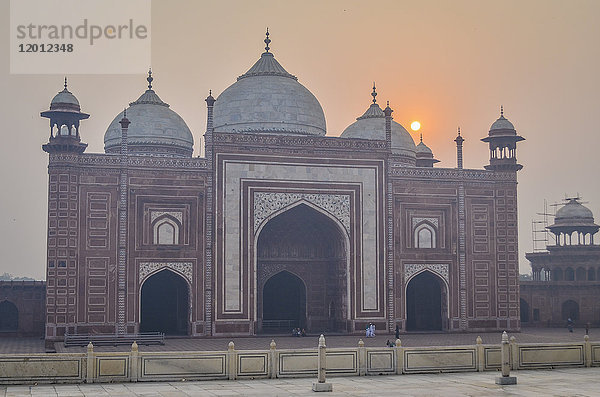 Außenansicht des Taj Mahal-Palastes und des Mausoleums  eines UNESCO-Weltkulturerbes  eines Palastes mit weißen Marmorwänden  in die dekorative Details eingelegt sind.