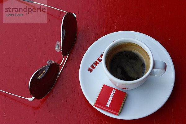 Frankreich  Departement Var  Stadt Saint-Tropez  Zoom auf eine Kaffeetasse  Sonnenbrille  auf einem roten Tisch des berühmtesten Restaurants ''chez Senequier''.