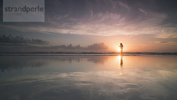 Silhouette Frau am Meeresufer gegen bewölkten Himmel bei Sonnenuntergang  Daytona  Florida  USA