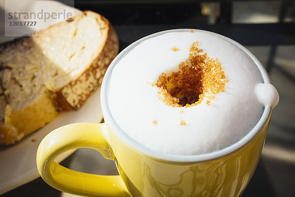 Blick auf frischen  schaumigen Kaffee mit braunem Zucker auf dem Tisch im Cafe