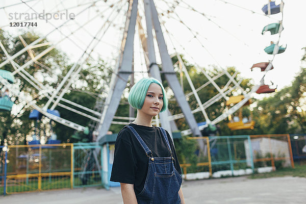 Porträt eines lächelnden Teenagermädchens am Riesenrad im Park