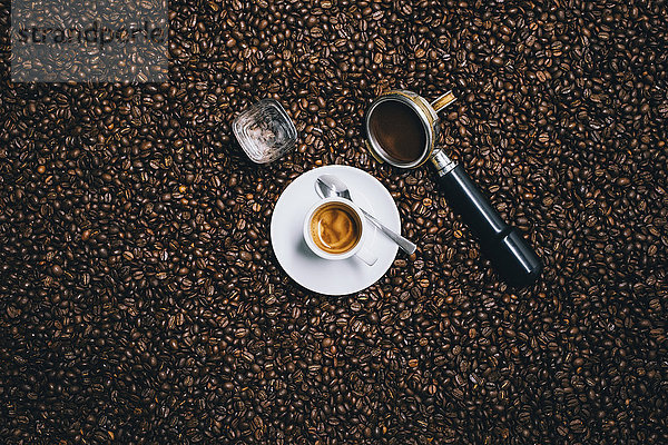 Direkt über der Espressotasse mit Filter auf gerösteten Kaffeebohnen