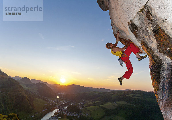 Freeclimber hängt an Felsen  Sonnenuntergang