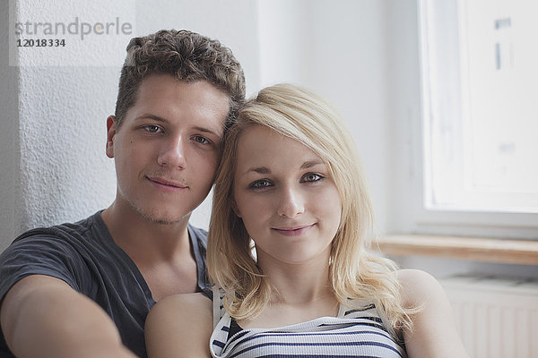 Porträt eines jungen Paares  das zu Hause sitzt