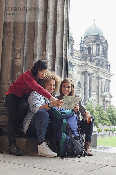 Junge Touristinnen beim Kartenlesen im Alten Museum gegen den Berliner Dom  Deutschland