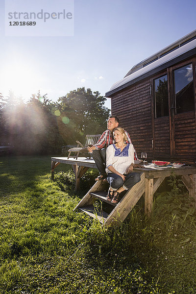 Ein reifes Paar  das sich bei einem Wein im Freien bei Sonnenschein entspannen kann.