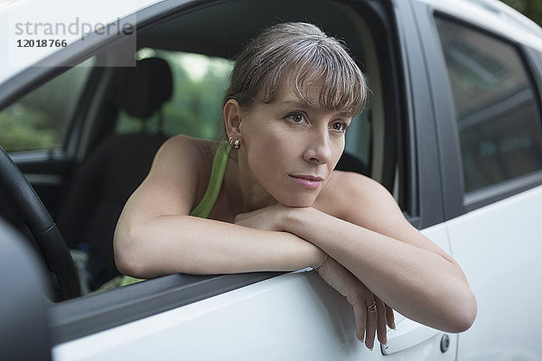 Nachdenkliche Frau im Auto sitzend