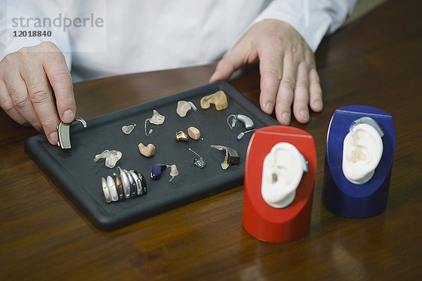 Mittelteil des Hörgeräteakustikers verschiedene Hörgeräte am Tisch in der Arztpraxis