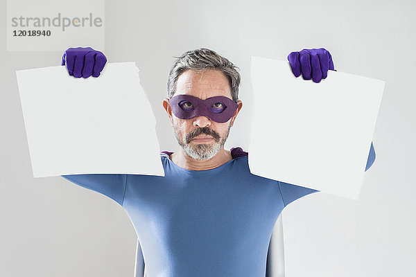 Porträt eines Superhelden mit gerissenem leeren Plakat auf weißem Hintergrund