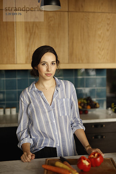 Porträt einer selbstbewussten Frau auf der Kücheninsel