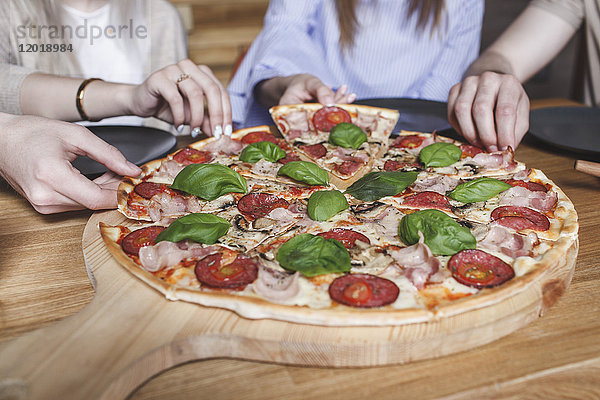 Abgeschnittenes Bild von Freunden beim Pizza essen im Restaurant