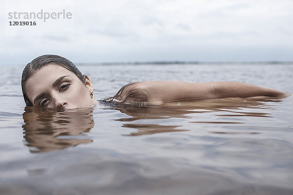Porträt einer jungen Frau  die im See schwimmt