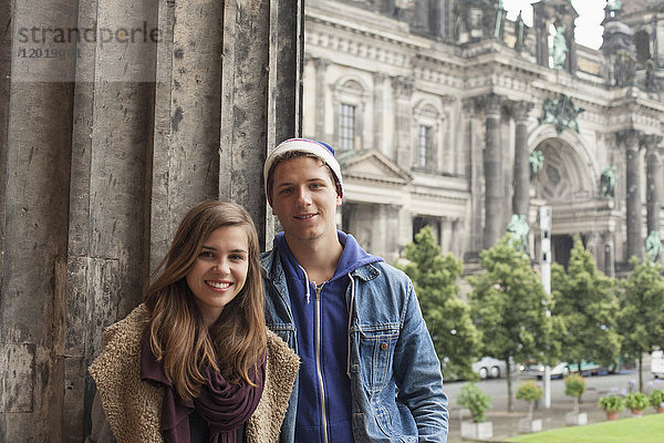 Porträt lächelnder junger Freunde an der Säule im Alten Museum gegen den Berliner Dom