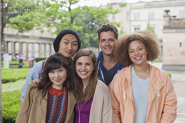 Porträt von lächelnden multiethnischen jungen Freunden im Freien