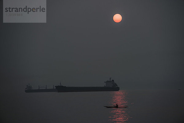 Silhouette Frachtschiffe auf See gegen den Himmel bei Nacht