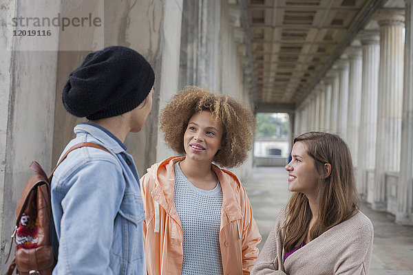 Junge multiethnische Freunde beim Reden im Flur  Berlin  Deutschland